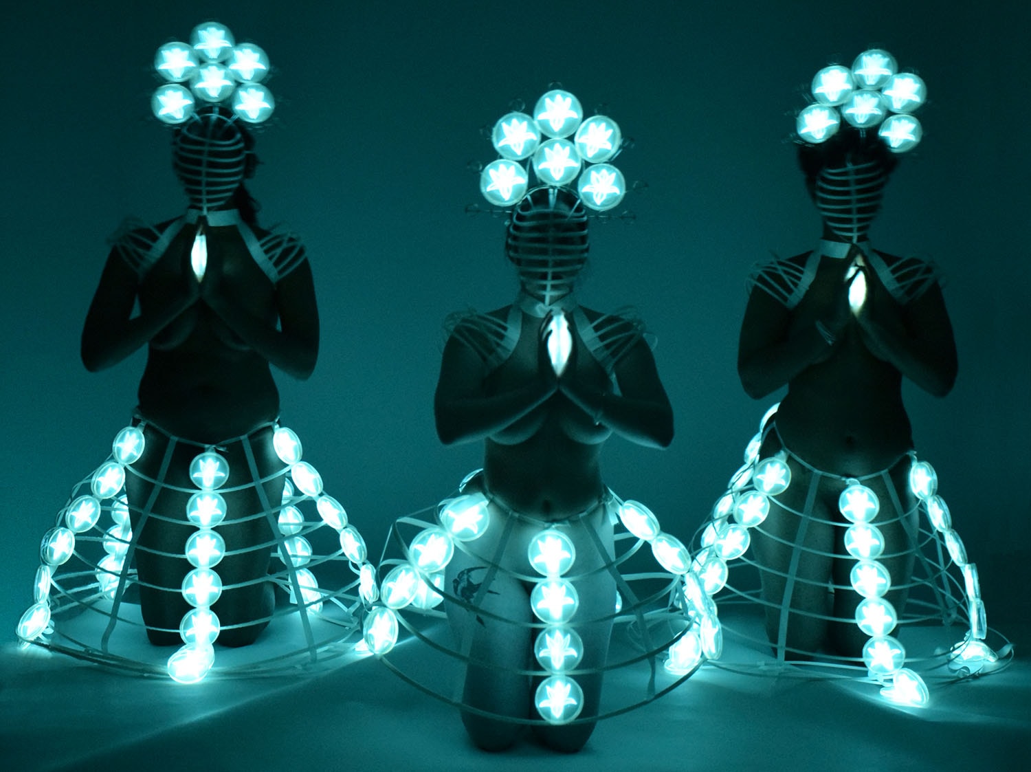 The Light of Prayer, figures wearing glowing bioluminescent forms
