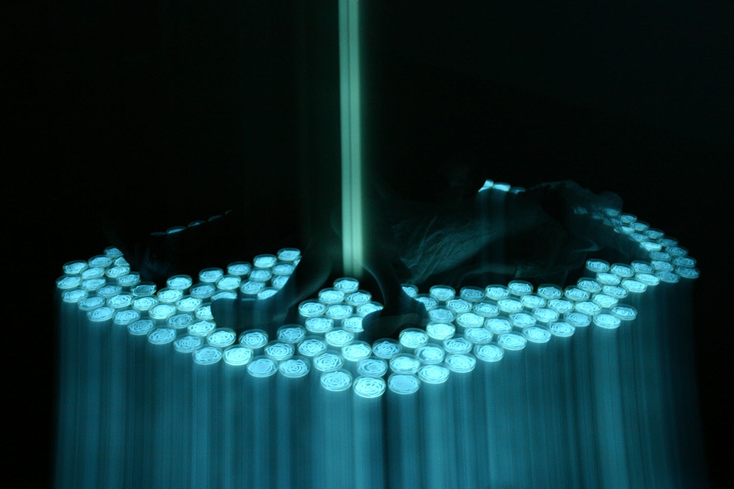 Two Beams of Light, cyan blue light forms and silhouetted figures